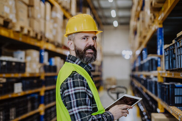 Portrait of a warehouse worker or supervisor with digital tablet.