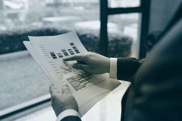 Close up of young business man and digital number of stock market background to represent...