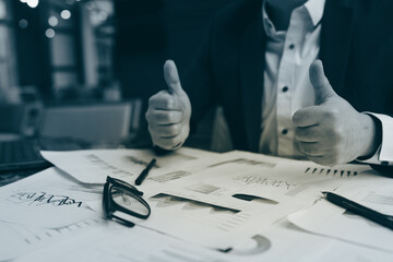 Close up of young business man and digital number of stock market background to represent...