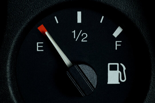 Close-up of a car dashboard, low fuel indicator on the dashboard in an empty car tank.