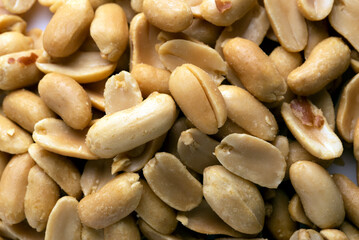 Sfondo di arachidi sgusciate e salate, cibo vegetariano 