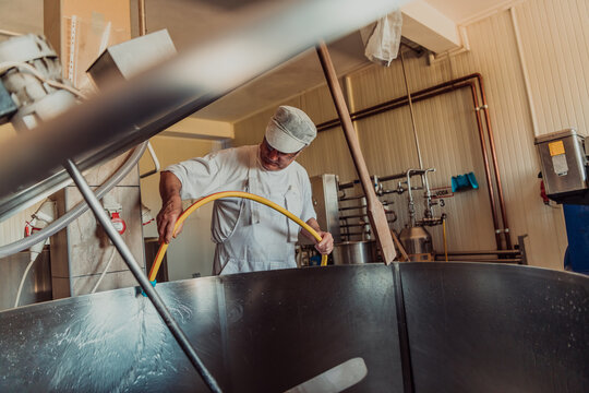 A cheese makser working in the industry on various machines with the help of which cheese is processed. Small business concept