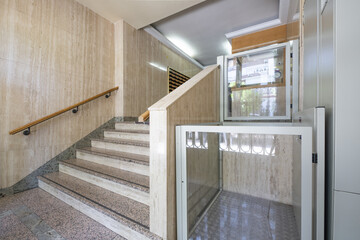 Portal of a residential building with granite stairs, marble walls and hydraulic elevator for...