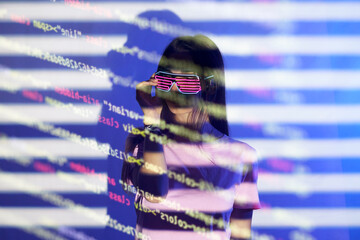 Young woman with futuristic eyewear reading codes over colored background