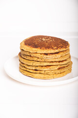 Delicious freshly cooked thick and fluffy gluten free pancakes stacked on white plate. Healthy food. Copy space for text.