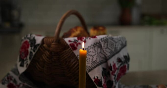 Easter burning candle on the background of basket with embroidered towel. Ukrainian style High quality photo