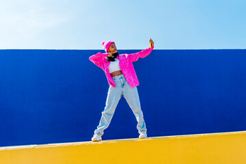 Young woman talking selfie over mobile phone on wall
