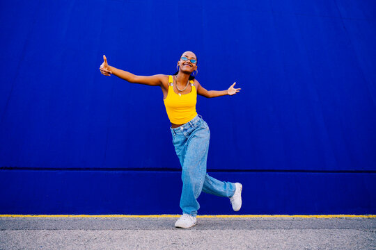 Smiling young dancer having fun dancing on footpath