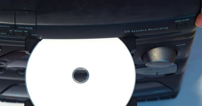 Hand removes the disc from the player.