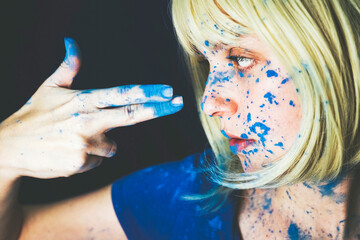 Woman making gun sign over black background