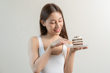 Portrait of attractive beautiful girl, asian young teenage woman holding a piece of chocolate cake,...