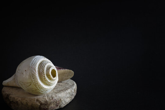 puja essentials conch shell with sandalwood stick and stone. symbolic to the rituals during hindu religious festivals like durga puja.