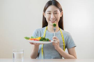 Diet, Dieting asian young woman or girl use fork at broccoli on mix vegetables, green salad bowl,...