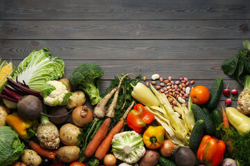 Different fresh vegetables on wooden table, flat lay with space for text. Farmer harvesting