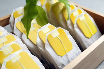 Wooden box with paper tea bags on table, closeup