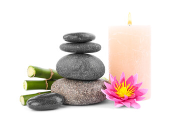Fototapeta na wymiar Stack of spa stones, bamboo stems, flower and candle isolated on white