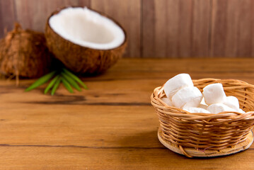 Coconut sweets on wooden table, coconut and coconut candies