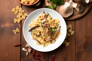 Piatto di deliziosa pasta piccante condita con funghi, aglio e prezzemolo, cibo italiano...
