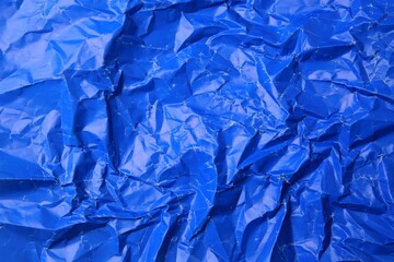 Sheet of crumpled blue paper as background, top view