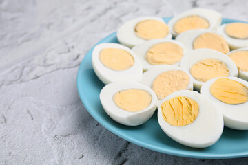Fresh hard boiled eggs on light grey textured table. Space for text