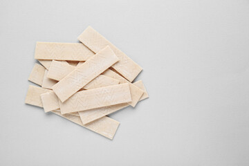 Many sticks of tasty chewing gum on light grey background, flat lay. Space for text - obrazy, fototapety, plakaty