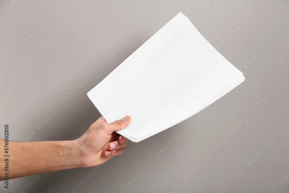 Sticker Man holding sheets of paper on grey background, closeup. Mockup for design