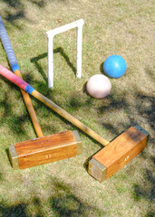 a hoop, 2 malletts and 2 balls from a game of Croquet in a garden - 576033641