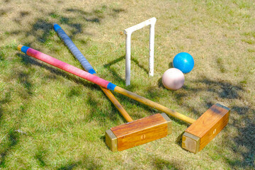 hoop, 2 malletts and 2 balls from a game of Croquet in a garden - 576033683
