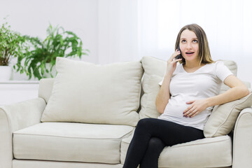 Obraz premium Pregnant woman sharing secrets and talking over the phone.
