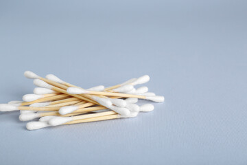 Wooden cotton buds on light grey background. Space for text