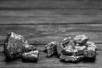 Naklejka premium Pile of silver nuggets on black wooden table. Space for text