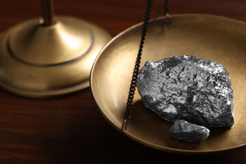 Vintage scales with silver nuggets on wooden table, closeup