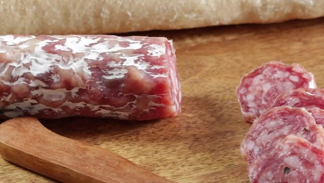 saucisson sec tranch&eacute; en gros plan sur une table en bois