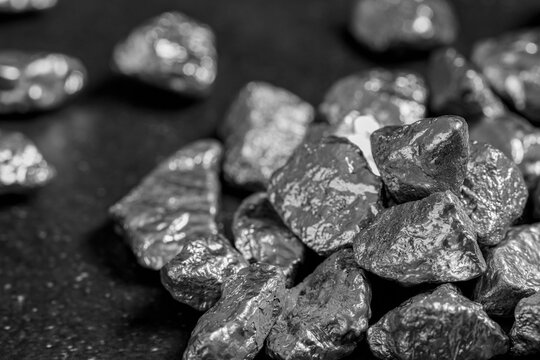 Pile of silver nuggets on black table, closeup