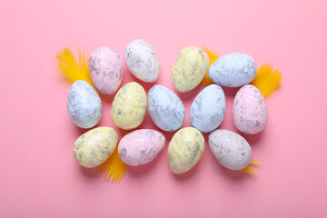 Many painted Easter eggs on pink background, flat lay