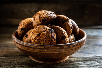 Homemade oatmeal cookies in a ceramic bowl on the kitchen table.