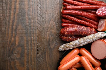 Different types of sausages on wooden table, flat lay. Space for text