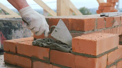 Laying out a brick chimney chimney of a private wooden house.