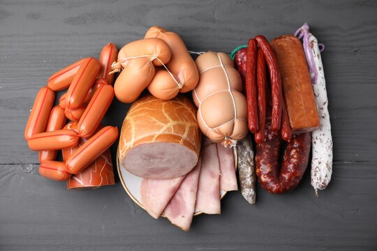 Different types of sausages on light grey wooden table, above view