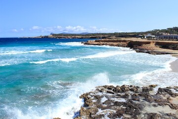 The paradisiacal beach of Cala Bassa in Ibiza in the Balearic Islands. Fantastic blue and turquoise sea and white sand beaches.