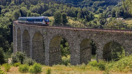 Fototapeta na wymiar A train on the high old viaduct near Novina, Czech republic