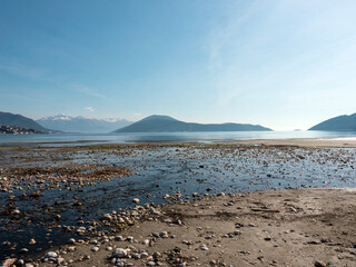 Pebbles and sand during sea low tide with mountains at background