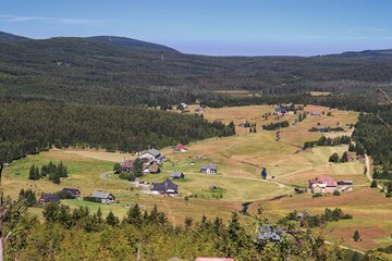 Obraz premium A view to the old village Jizerka with traditional houses in the heart of mountains at Czech republic