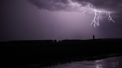 Naklejka na ściany i meble lightning flashes at night over the field