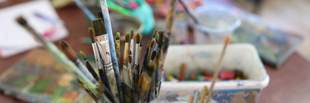 Glasses with brushes for painting at artist workplace