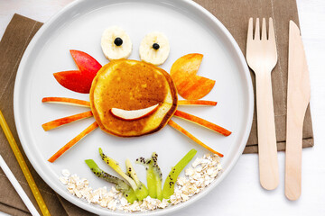 Funny crab face shape snack from pancake,apples,banana,kiwi on plate. Cute kids childrens baby's...
