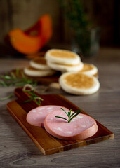 slices of Bologna PGI mortadella on wooden cutting board