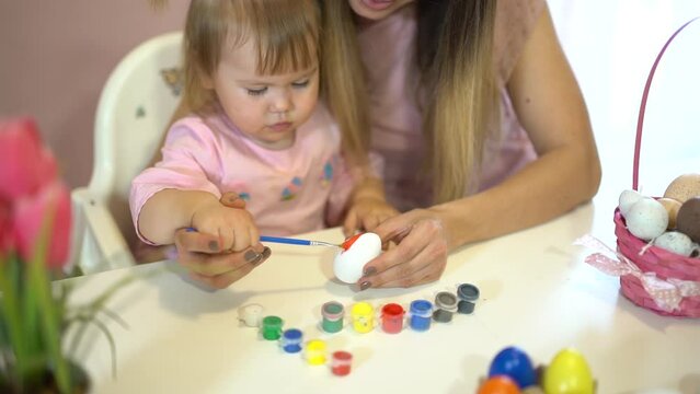 mother and child painting easter eggs