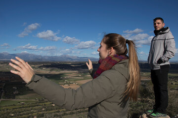 Two young hikers contemplate the landscape of the island of Mallorca on a sunny winter day.