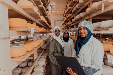 Arab business partners checking the quality of cheese in the industry and enter data into a laptop. Small business concept